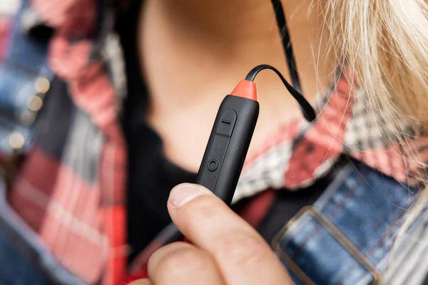 Duim op het bedieningspaneel van een bluetooth-gehoorbescherming